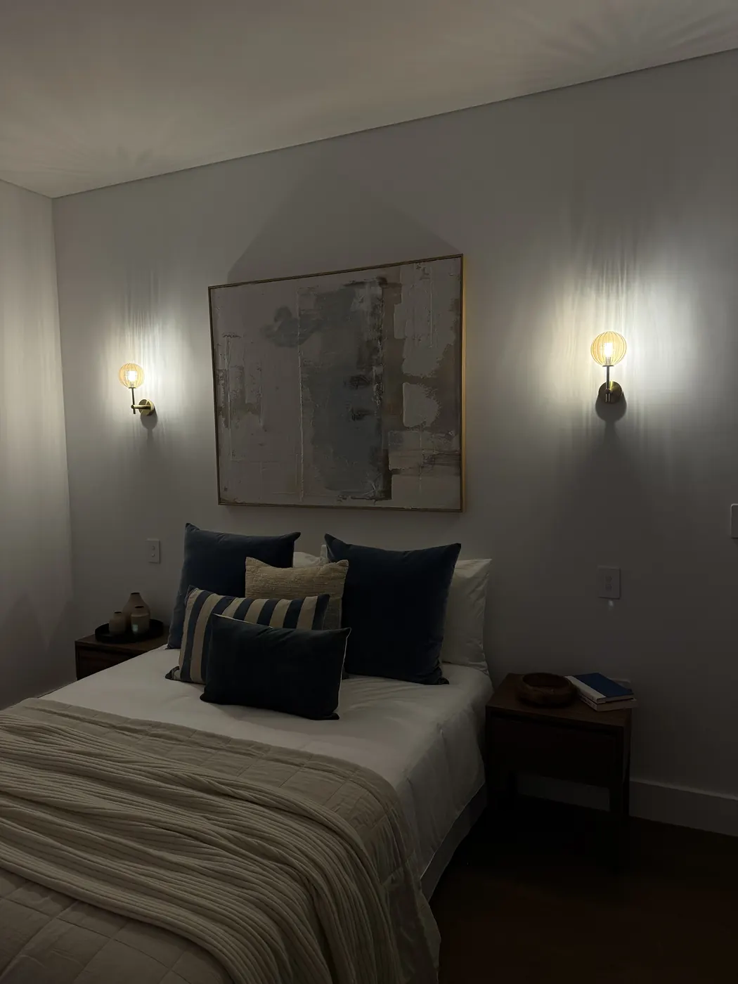 Wall lights either side of a bed in a modern bedroom