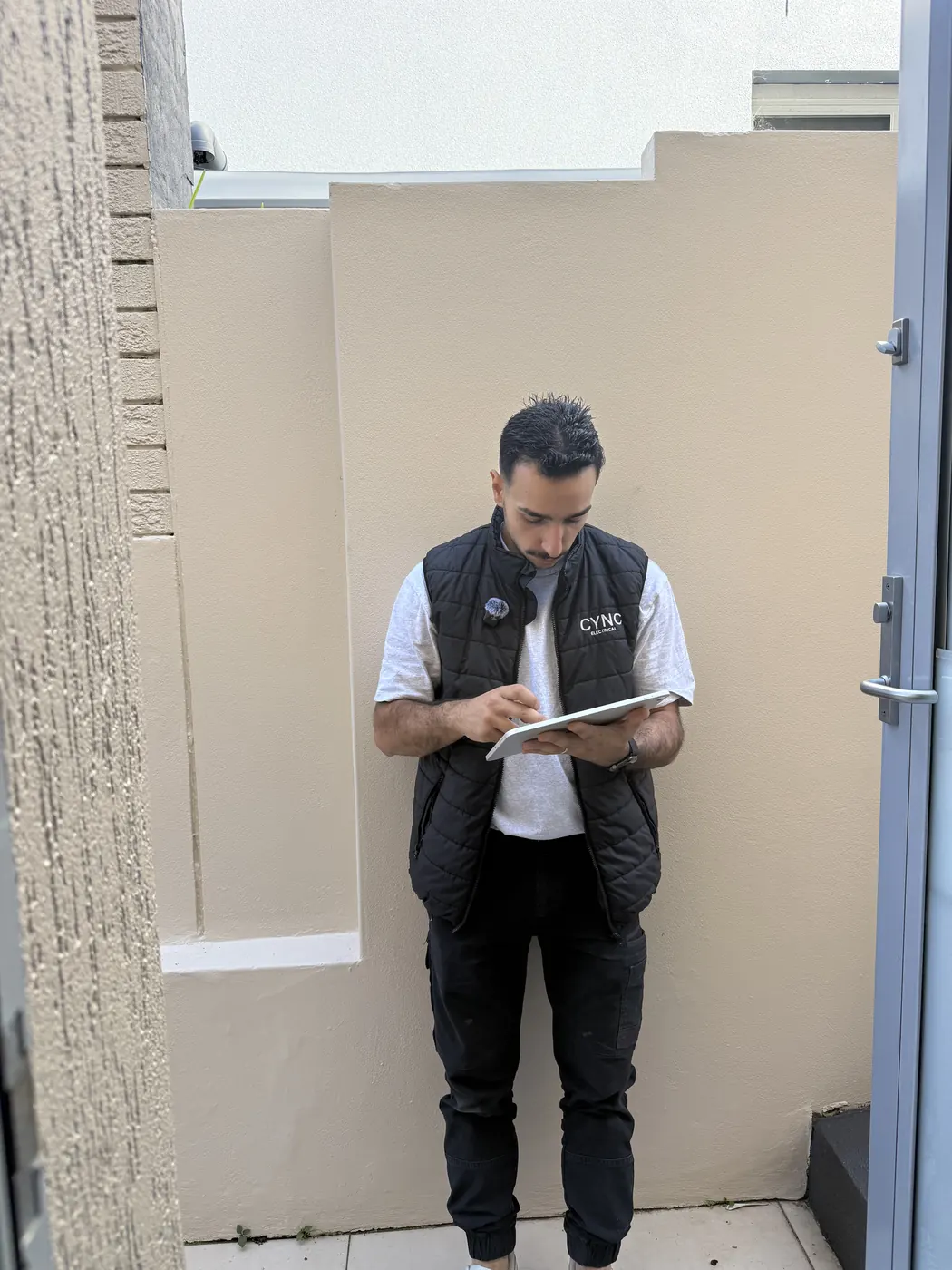 An electrician walking a customer through a quote on a tablet