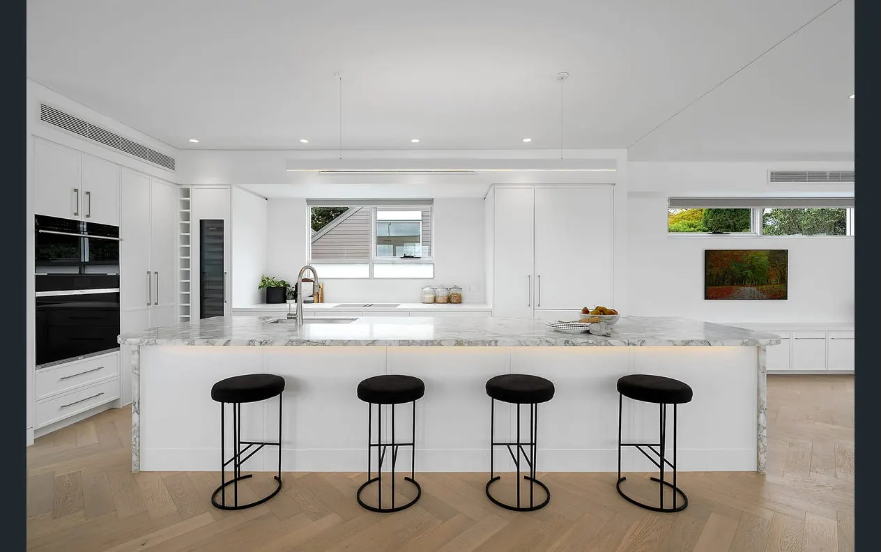 A renovated kitchen with island bench and downlights