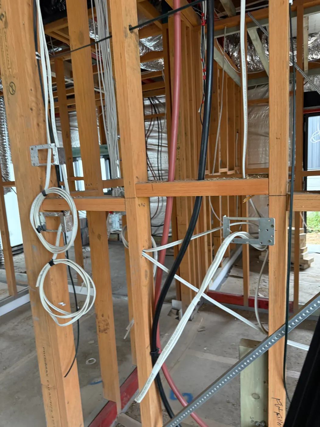 Rough-in wiring pulled through a timber-framed wall