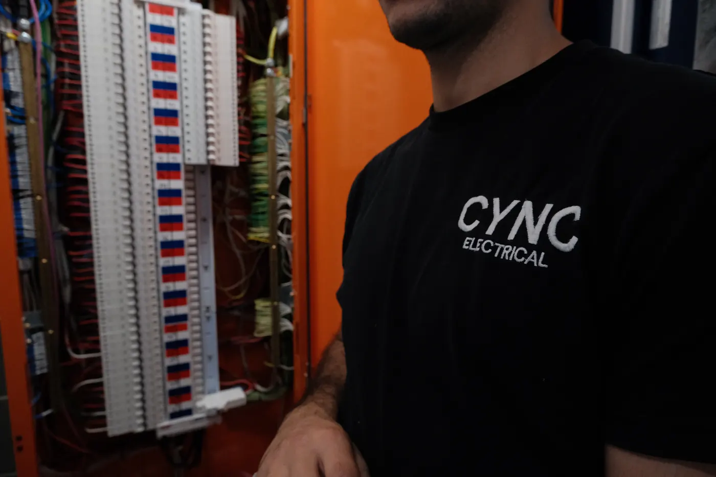 An electrician working inside an open switchboard